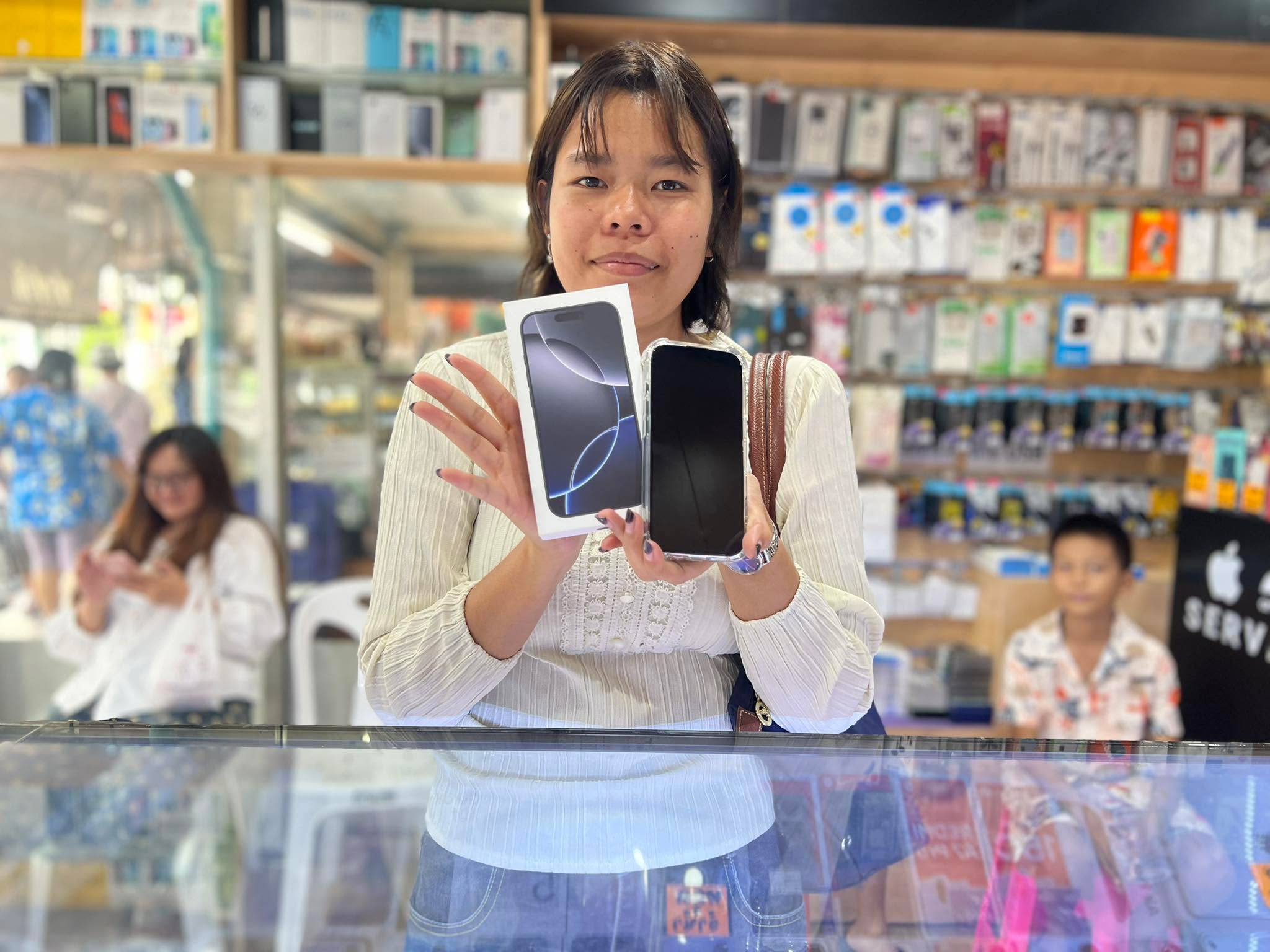 ลูกค้าถือโทรศัพท์และกล่องอุปกรณ์ที่เคาน์เตอร์ร้าน